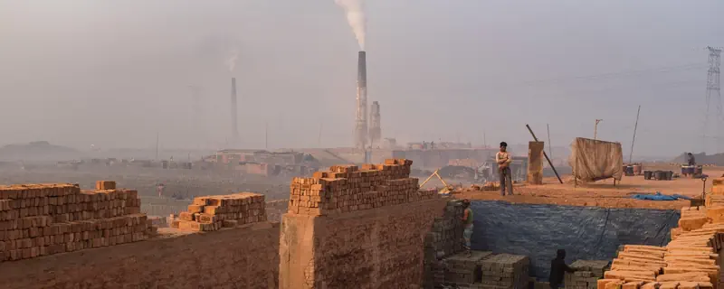 Brick kiln landscape with visible industrial smoke and stacked bricks