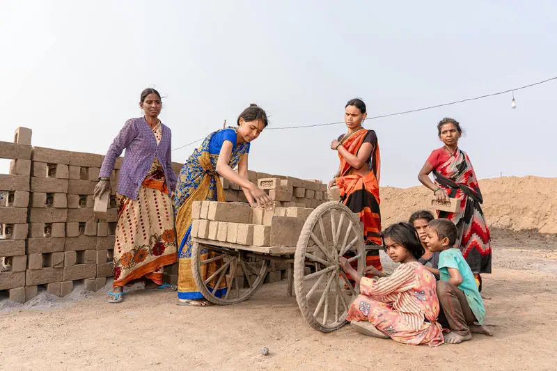 Workers and children near brick production activity